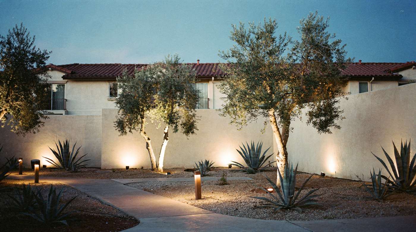 A community courtyard at dusk with the path lights on